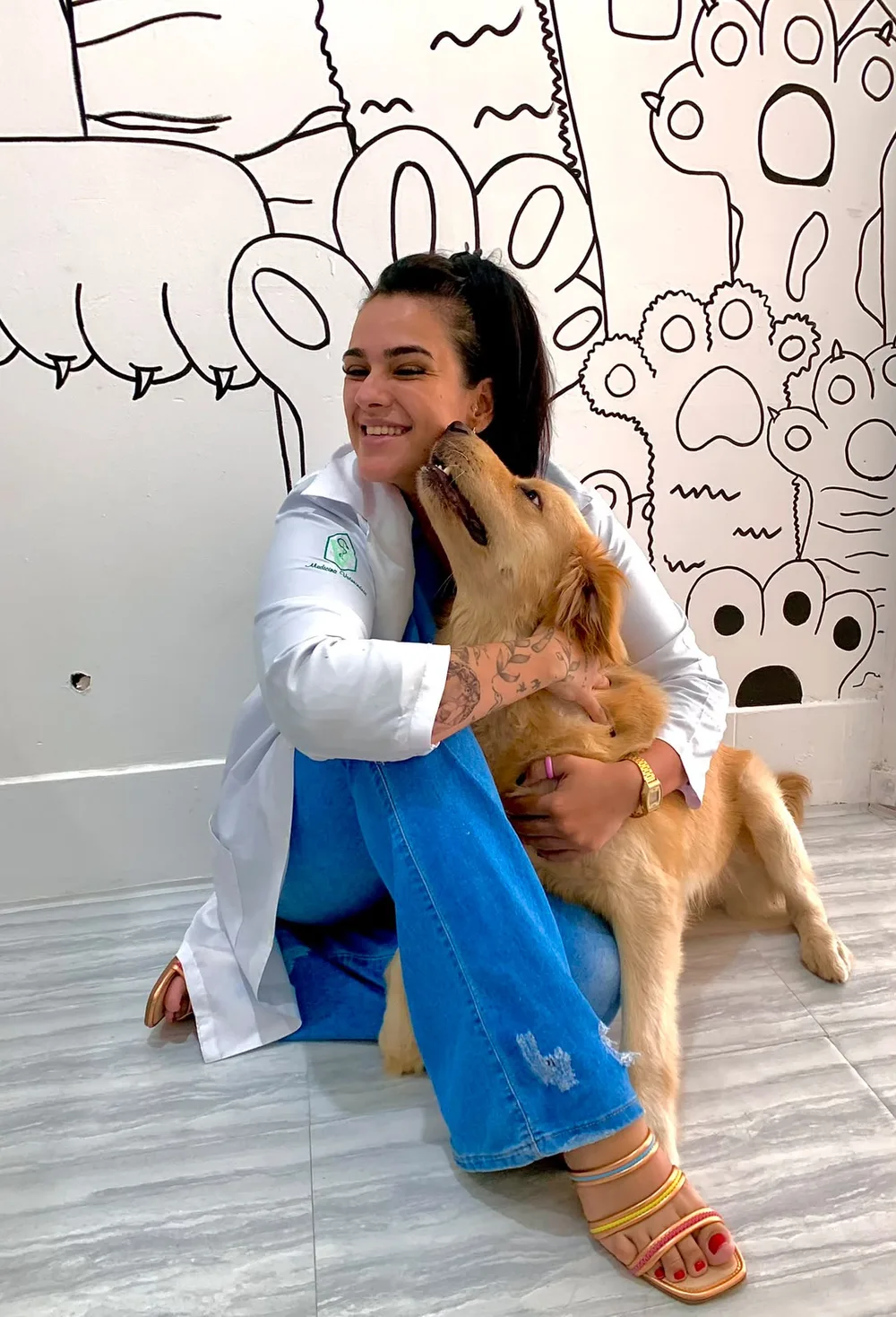 Dra. Huana Gouvea abraçando um golden retriever